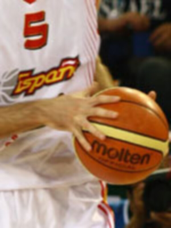 Un jugador de baloncesto con el número 5 en su camiseta, sosteniendo un balón de la marca Molten.