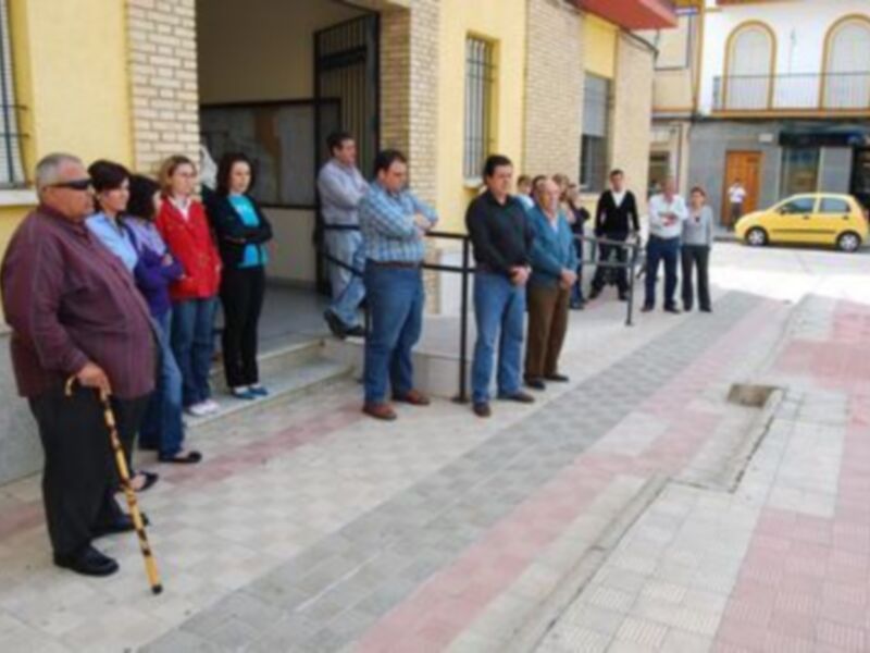 Gente reunida en una calle urbana, posiblemente para una reunión o evento público.