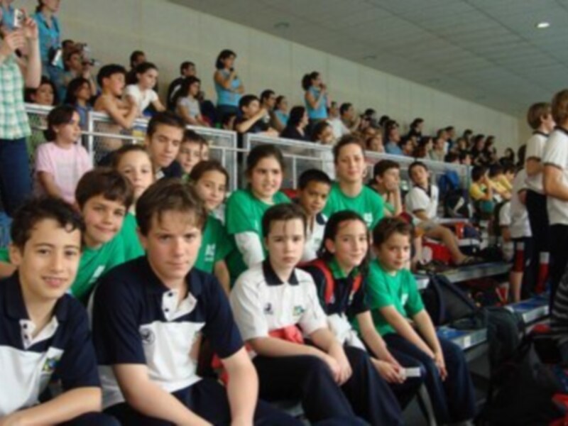 Jóvenes estudiantes en un estadio, posando para una foto en un evento escolar.