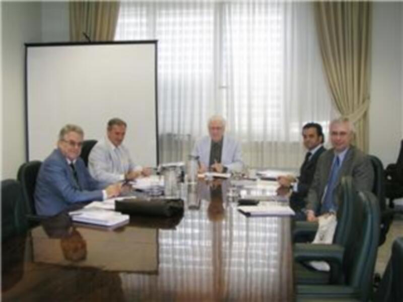 Una reunión de negocios en una sala de conferencias con una proyección en el fondo.