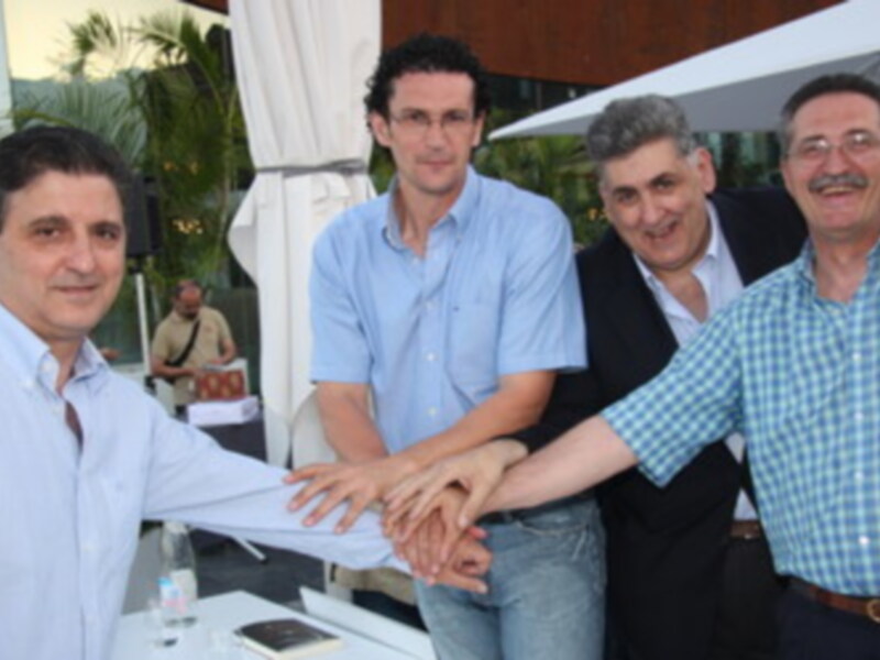 Celebración de un acuerdo entre cuatro hombres en una reunión al aire libre.