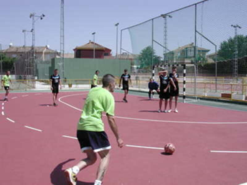 Jugadores de pelota valona en acción en un campo al aire libre.