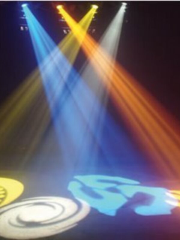 Rayos de luz multicolores en un escenario, destacando un diseño gráfico en el suelo.