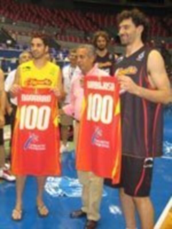 Jugadores celebrando con banderas que indican el número 100 en un evento deportivo.