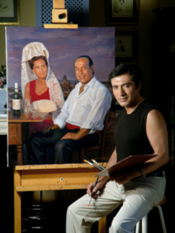 Artista posando junto a su obra de retrato de pareja en un estudio pintoresco.