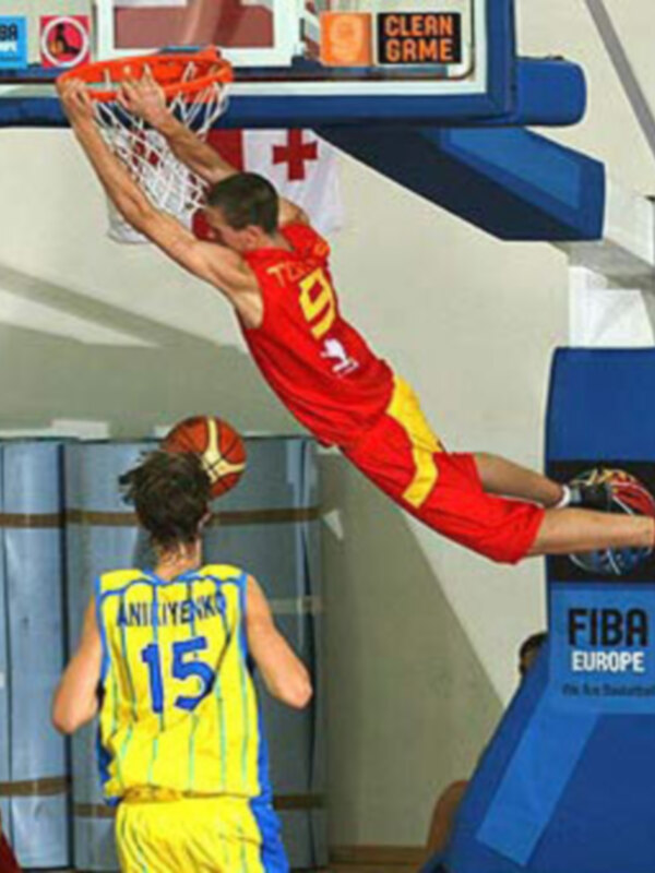 Un jugador de baloncesto realiza un salto durante un partido de la FIBA Europe Cup, con el marcador en el fondo mostrando 'Clean Game'.
