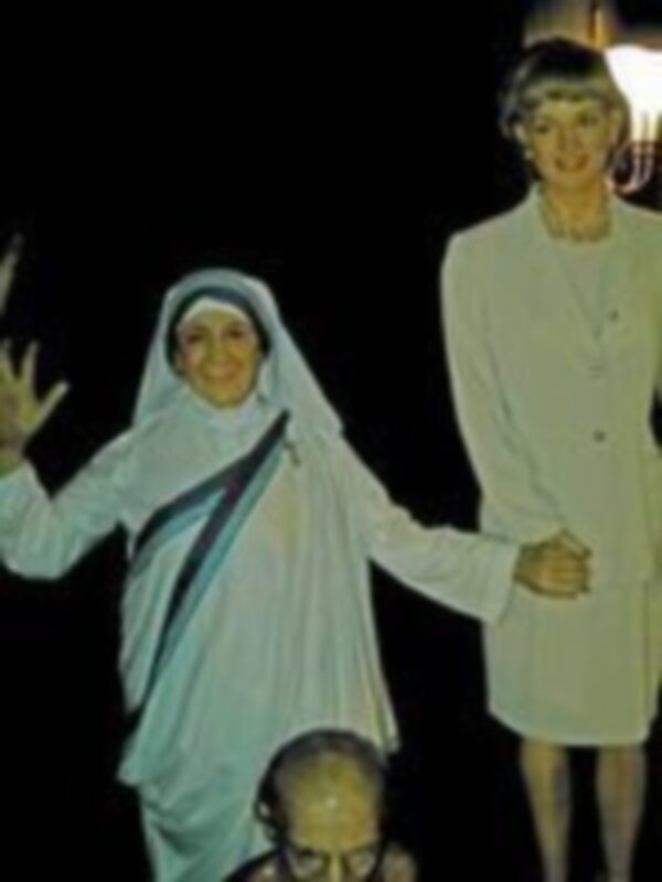 Una imagen histórica que muestra a una mujer vestida con un velo blanco y una niña en un vestido blanco, posando juntas.