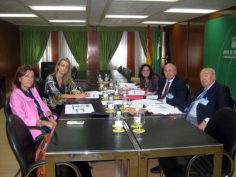 Reunión de trabajo en una sala de conferencias con un grupo de personas sentadas alrededor de una mesa.