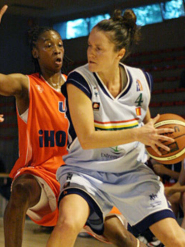Jugadoras de baloncesto en acción durante un partido, una en ataque y otra defendiendo.