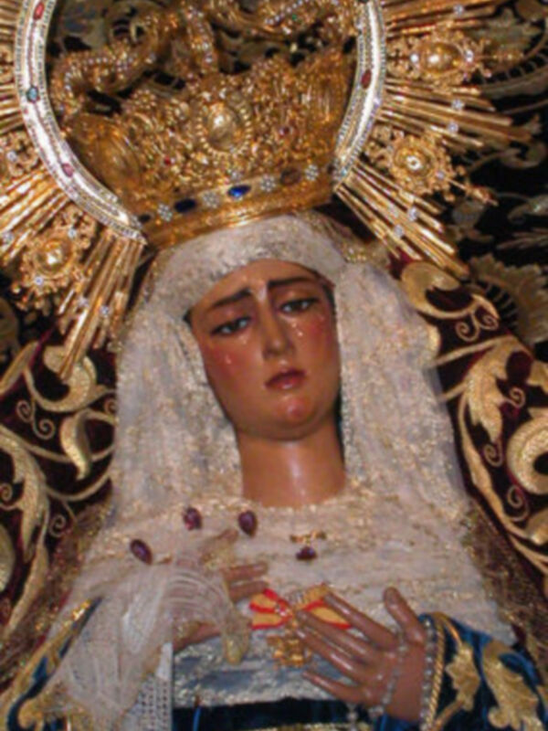 Imagen de una Virgen María vestida con una saya y un manto de terciopelo, con una corona de oro y piedras preciosas.