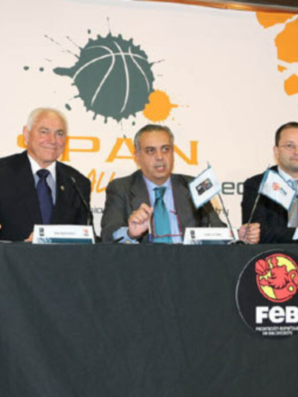 Tres hombres en una conferencia de prensa sobre baloncesto, con el logo de la FEB en el fondo.