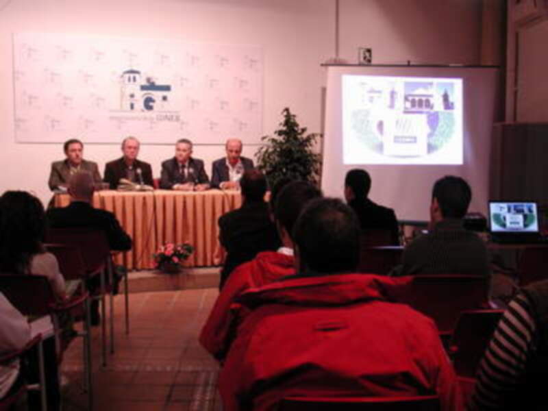 Presentación en sala con audiencia y pantalla proyectando ilustración.