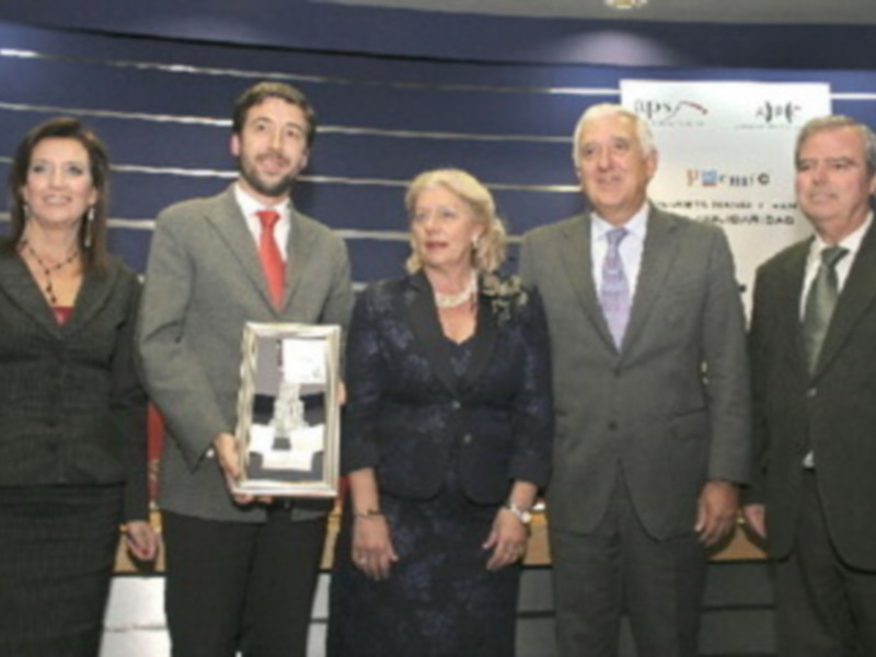 Una imagen de una reunión empresarial donde una persona sostiene un premio mientras otros la felicitan. El contexto sugiere un ambiente de reconocimiento y éxito empresarial.
