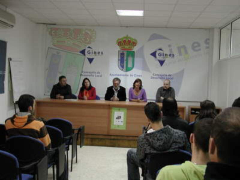 Conferencia en Gines, Andalucía, España, con autoridades locales y público asistente.
