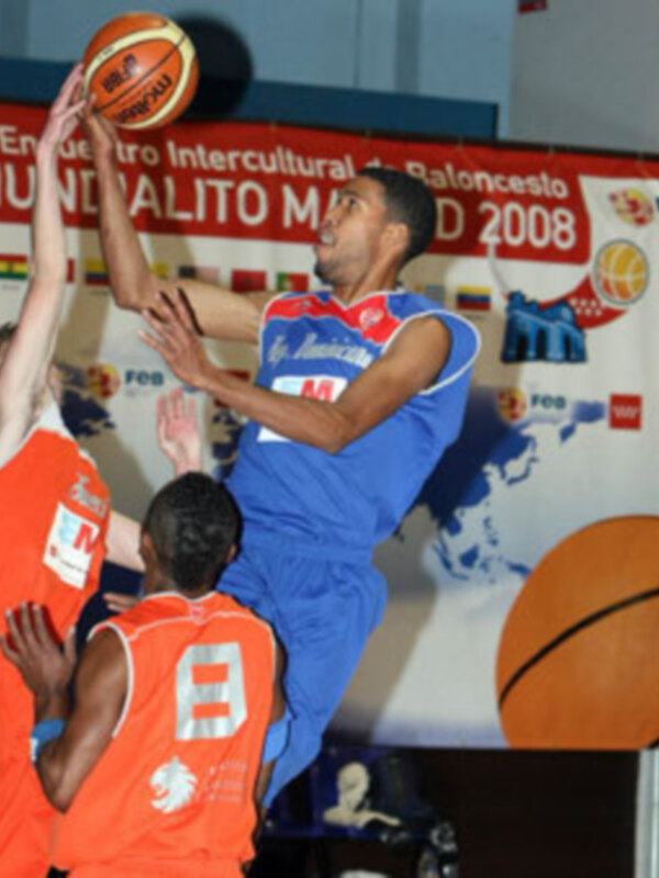 Jugador azul encestando durante un partido de baloncesto en el 2º Encuentro Intercultural de Baloncesto Mundialito Madrid 2008.