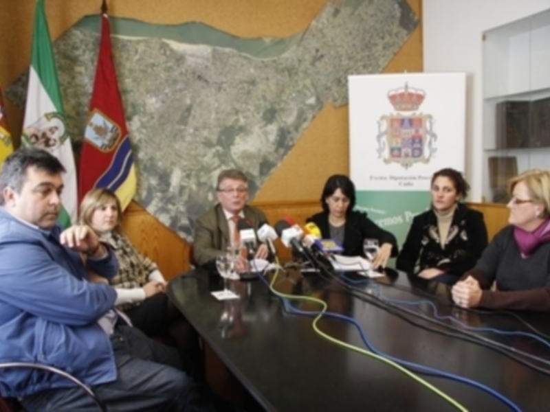 Conferencia de prensa en una sala con banderas y carteles oficiales, donde se discuten temas de importancia pública.
