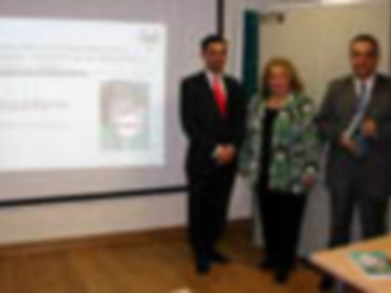 Presentación en una conferencia con dos personas en primer plano y un proyector en el fondo.