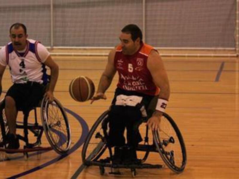 Jugadores de baloncesto en silla de ruedas en acción durante un partido.