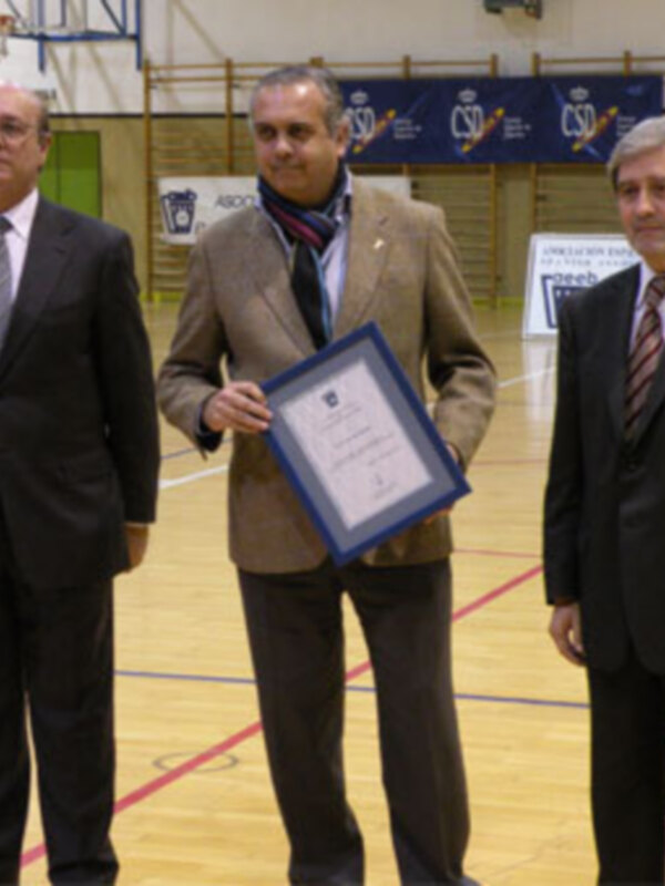 Entrega de un reconocimiento en una ceremonia en un gimnasio.