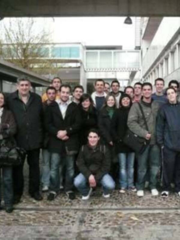 Grupo de estudiantes en un patio de la universidad, posando para una foto.