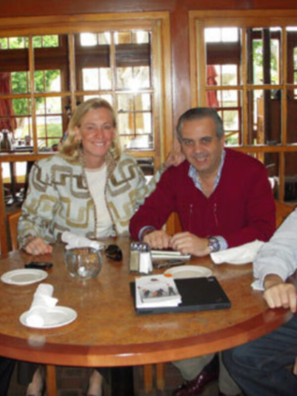Reunión de negocios en un ambiente acogedor, con cuatro personas sentadas alrededor de una mesa redonda.