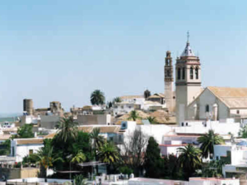 Imaginación de un paisaje urbano con edificios y torres en el horizonte, bajo un cielo claro y azul.