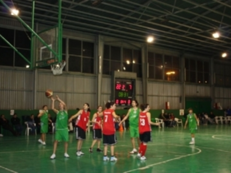 Equipo de baloncesto en acción durante un partido en una cancha deportiva.