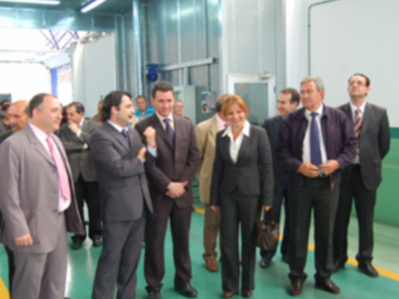Visita de autoridades en una fábrica moderna, intercambiando ideas en un ambiente industrial.