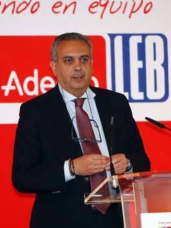 Hombre en traje hablando en un evento público con el logo de la LEB en el fondo.