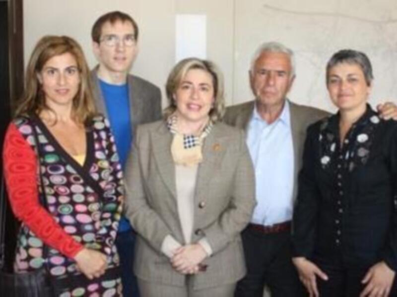Un grupo de personas posa juntos en un entorno formal, posiblemente en una reunión o evento profesional.
