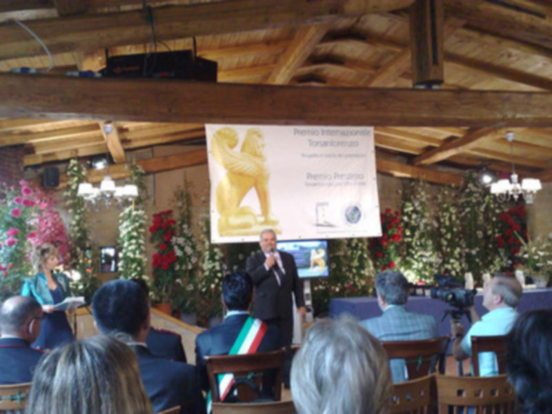 Premio Pergamino Torani 2009: evento en un salón decorado con flores y un león dorado en el cartel.