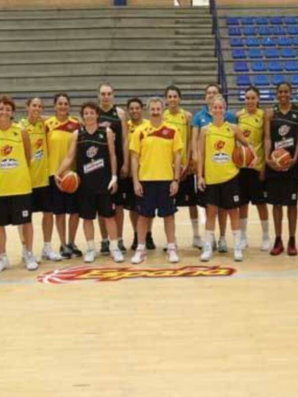 Equipo femenino de baloncesto posando en el estadio.