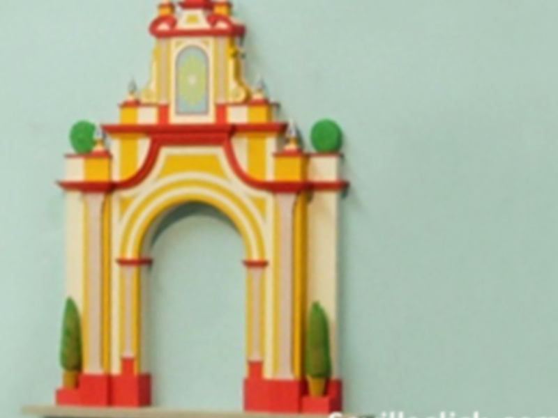 Arco decorativo con detalles antiguos, colocado sobre un estante en una pared de color claro.