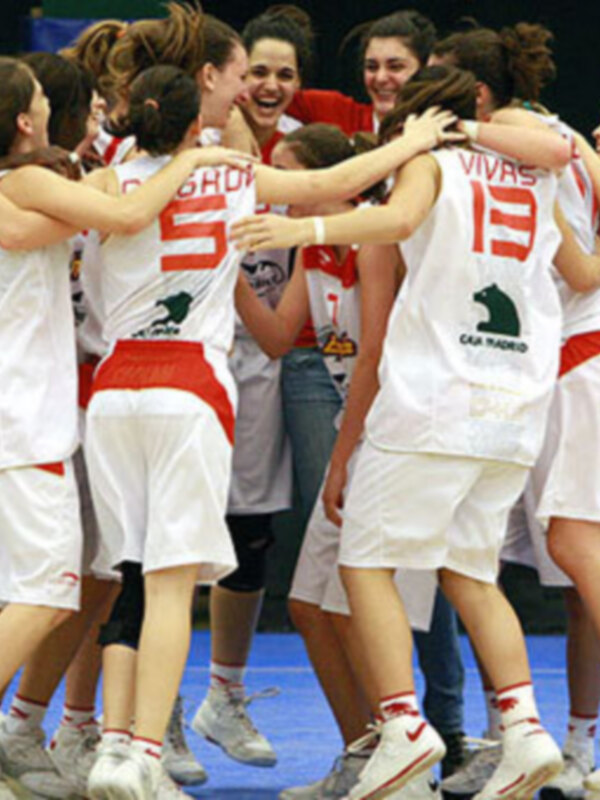 Celebración de equipo de baloncesto femenino en el centro del campo.