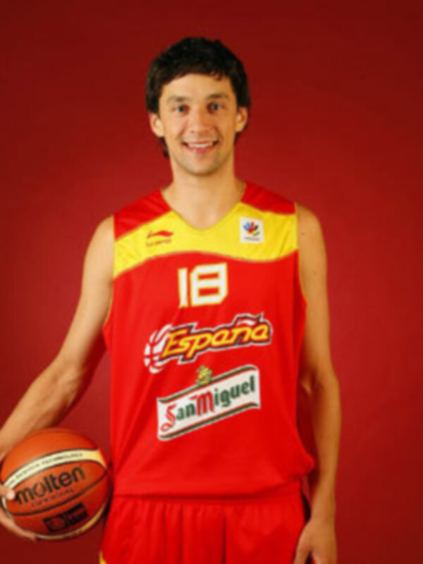 Un jugador de baloncesto en una camiseta roja con el número 18 y la palabra 'España' en el pecho, sosteniendo una pelota de baloncesto en la mano izquierda. El fondo es rojo.