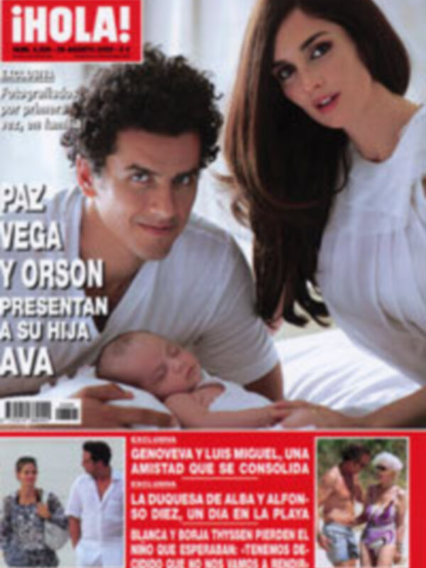 Portada de revista con una familia feliz presentando a su bebé recién nacido.