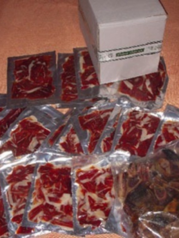 Un paquete de salchichas en envases de aluminio sobre una superficie de color naranja.