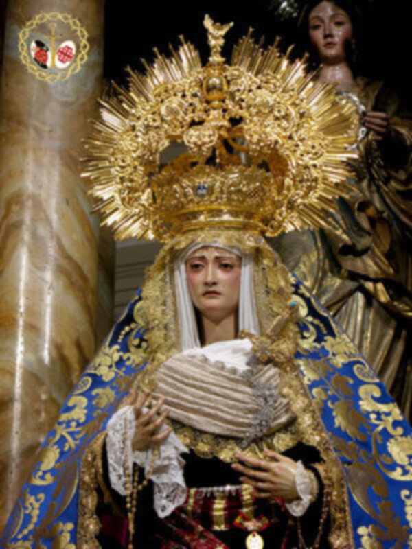 Sagrada imagen de la Virgen María con vestimentas y corona dorada, representando un momento de devoción religiosa.