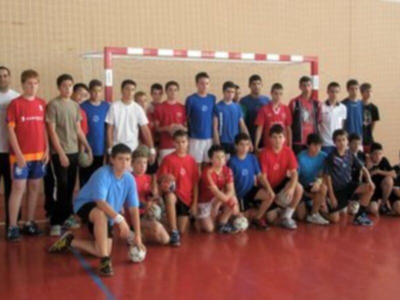 Equipo de fútbol sala juvenil posando en una cancha de deportes.