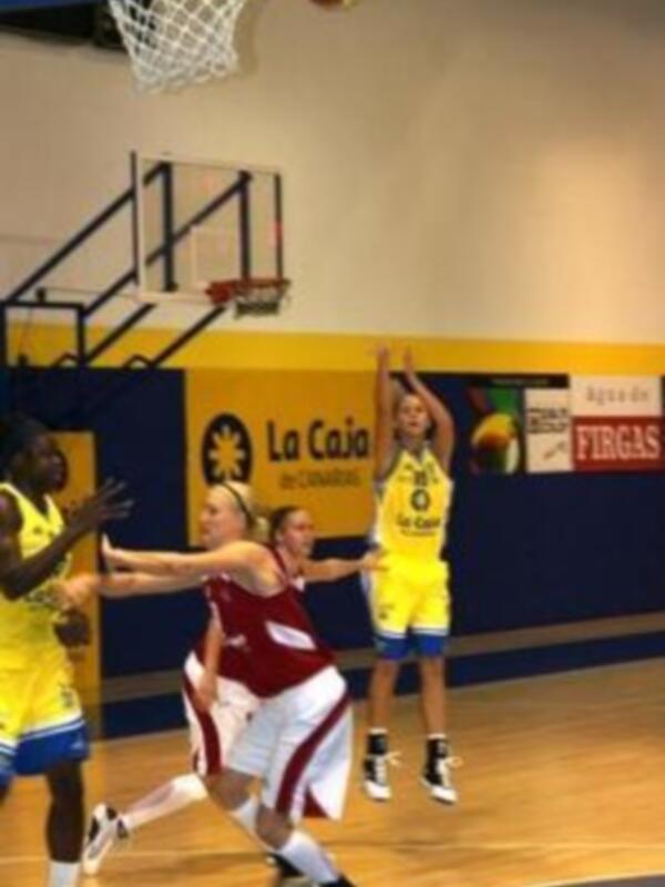Jugadores de baloncesto en acción durante un partido en una cancha deportiva.