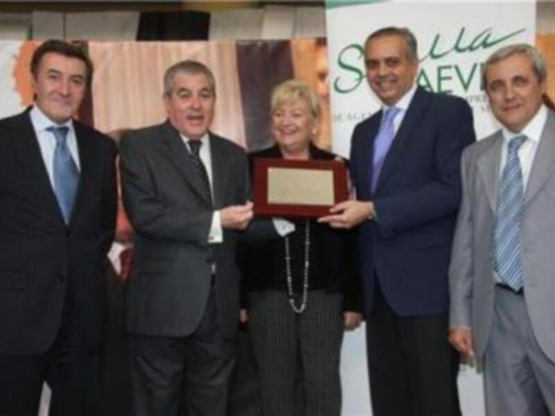 Entrega de reconocimiento en un evento formal con representantes de organizaciones agrícolas.