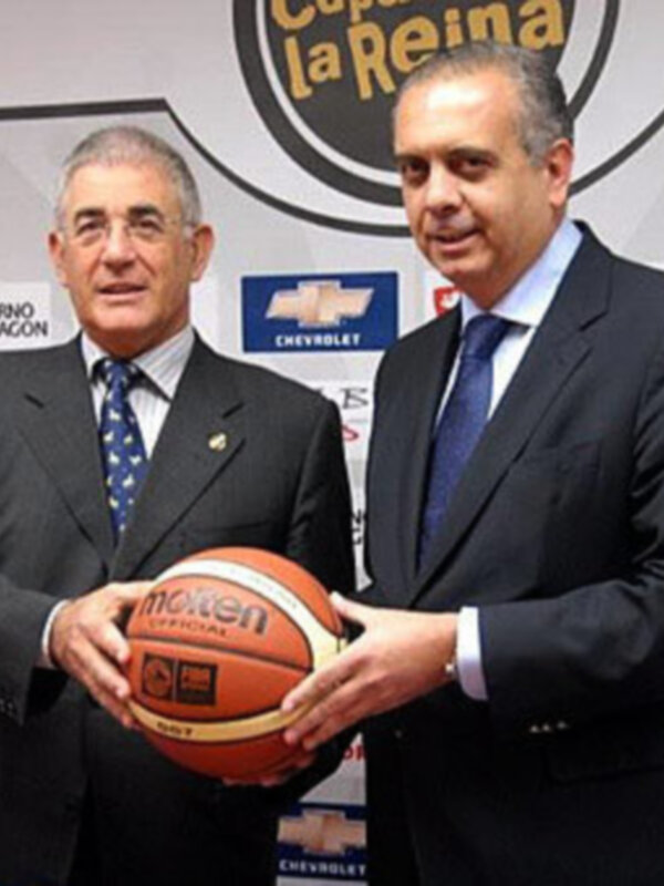 Dos hombres en trajes sostienen una pelota de baloncesto, con un fondo que incluye logos de Chevrolet y el nombre 'Copa la Reina'.