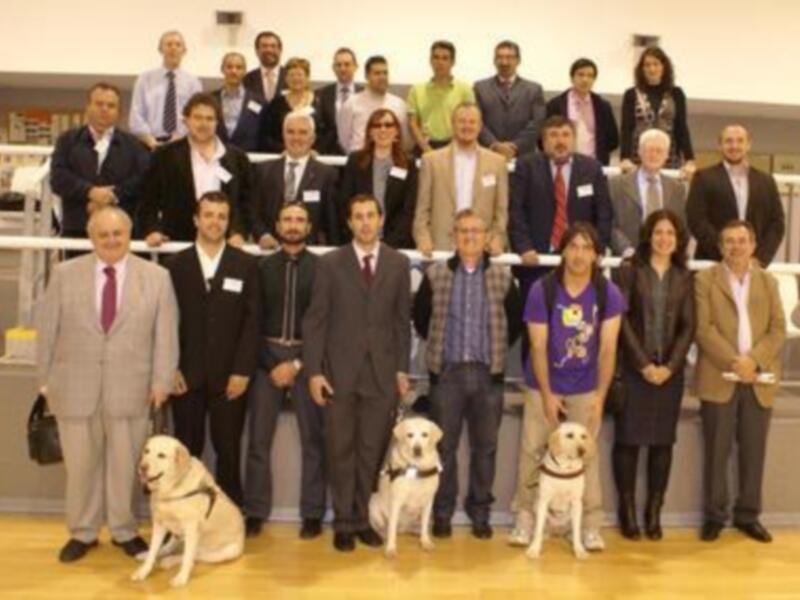Grupo de personas y perros guías en una reunión o evento formal.