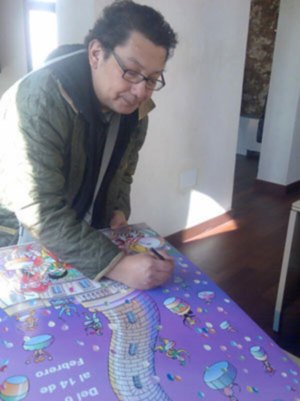 Persona firmando en un mural temático de castillos y fantasía en una mesa de colores vibrantes.