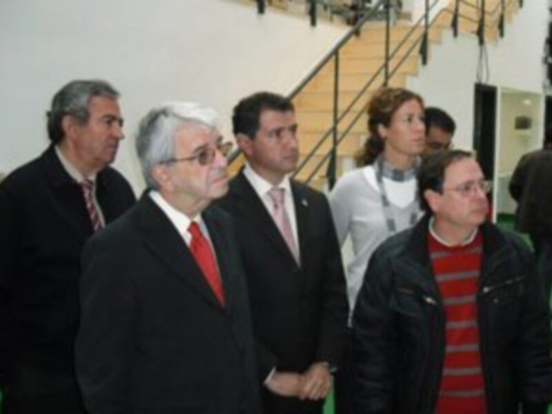 Una escena formal con personas en trajes y chaquetas, posiblemente en una reunión o evento.
