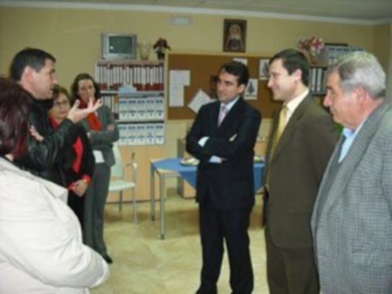 Reunión de negocios en una sala de oficina con personas discutiendo y mirando documentos en una mesa.