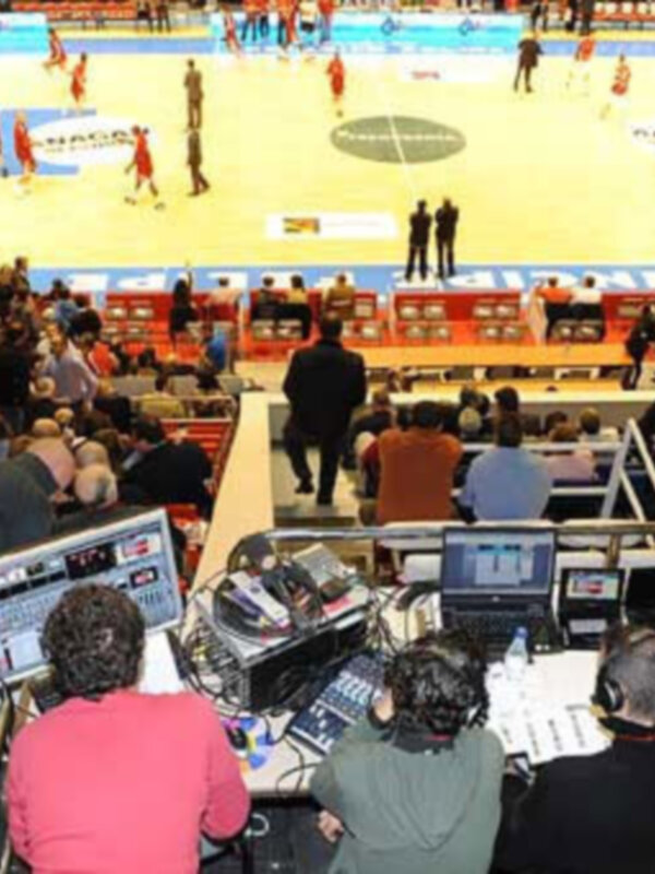 Equipo de producción en una instalación deportiva durante un evento de baloncesto.