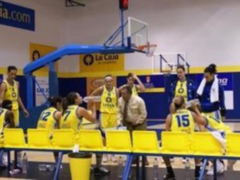 Equipo de baloncesto celebrando en el banquillo durante un partido.