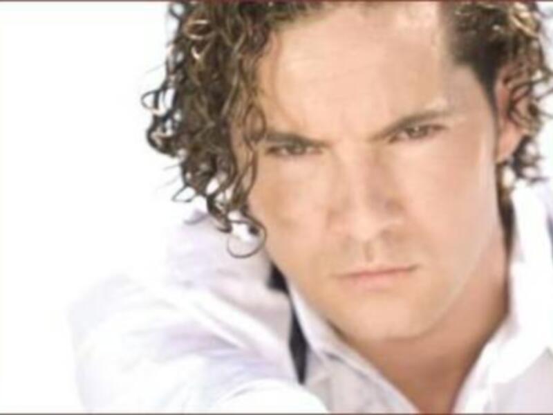 Retrato de hombre con cabello rizado y camisa blanca, expresión seria.