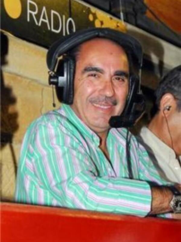 Un hombre con auriculares y una camisa a rayas en un estudio de radio